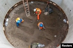 Các nhà khảo cổ học làm việc trên bộ xương được khai quật - có thể là hài cốt của các nạn nhân Cái chết đen - ở khu vực Farringdon của Luân Đôn trong bức ảnh phát tay chưa đề ngày này từ tháng 3 năm 2013.