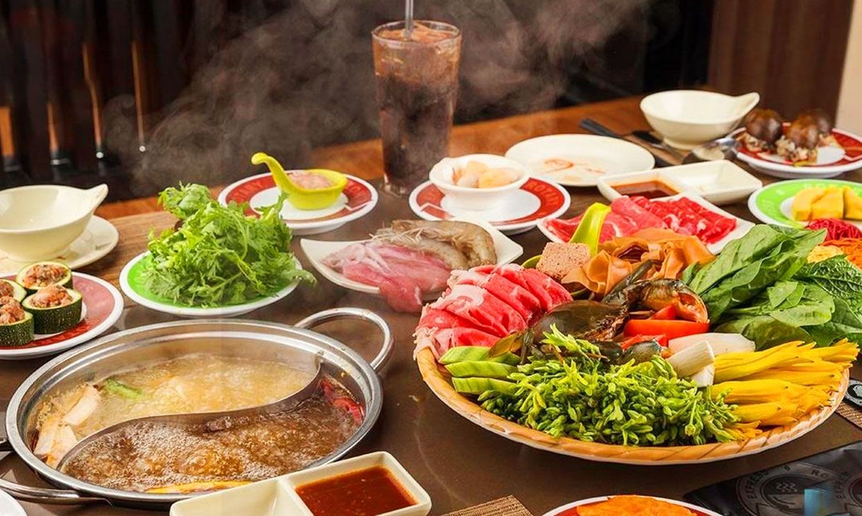 Hình ảnh các loại nguyên liệu tươi ngon trên băng chuyền lẩu Kichi-Kichi, bao gồm thịt, hải sản, rau xanh và nấm.