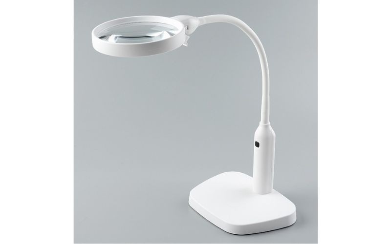 Một chiếc kính lúp để bàn với đèn LED chiếu sáng, giúp quan sát rõ hơn