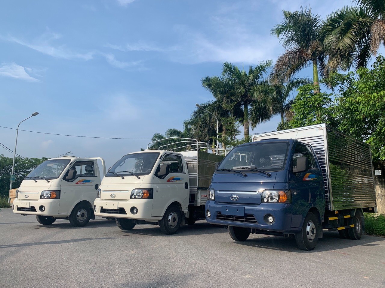alt: Hình ảnh xe tải Teraco 180 màu trắng, thùng lửng, đang đậu trên đường.
