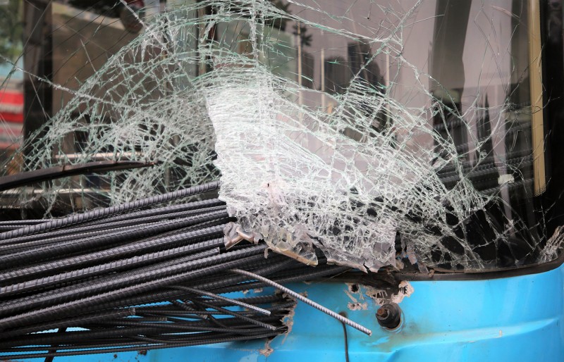 Dégâts importants à l'avant du bus après la collision avec le tricycle à moteur transportant des barres de fer.
