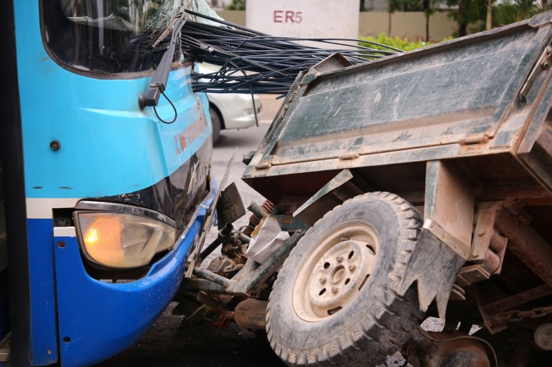 Un tricycle à moteur transportant une charge excessive de marchandises, soulignant le manque de sécurité et le risque d'accident.