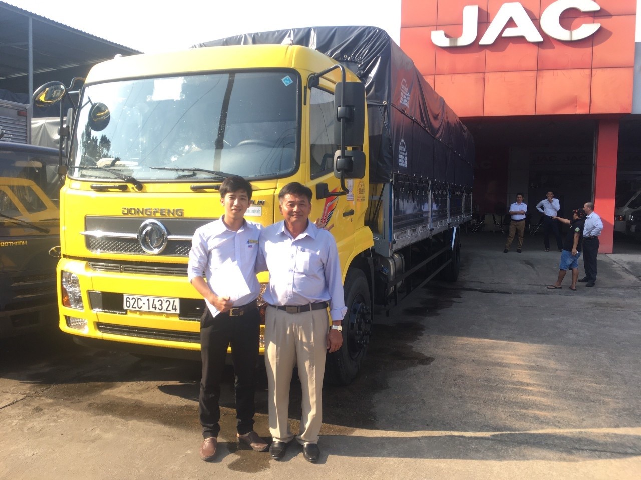 Un cliente orgoglioso accanto al suo nuovo camion Dongfeng appena acquistato da Phú Cường Auto