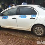 alt text: Hình ảnh xe taxi 27-7 màu trắng có gắn hộp đèn trên nóc