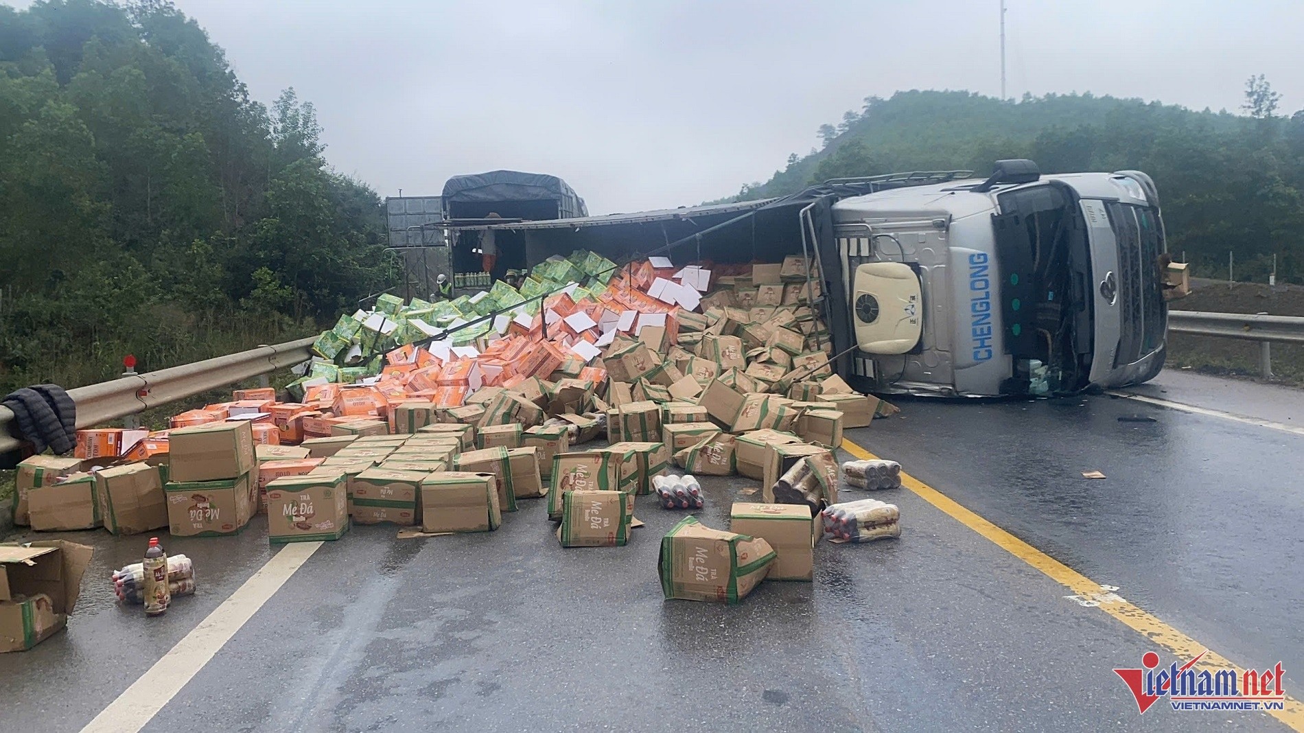 Image d'un camion de marchandises renversé en travers de l'autoroute Cam Lộ - La Sơn, section traversant Hải Lăng, Quảng Trị, après l'accident de la circulation