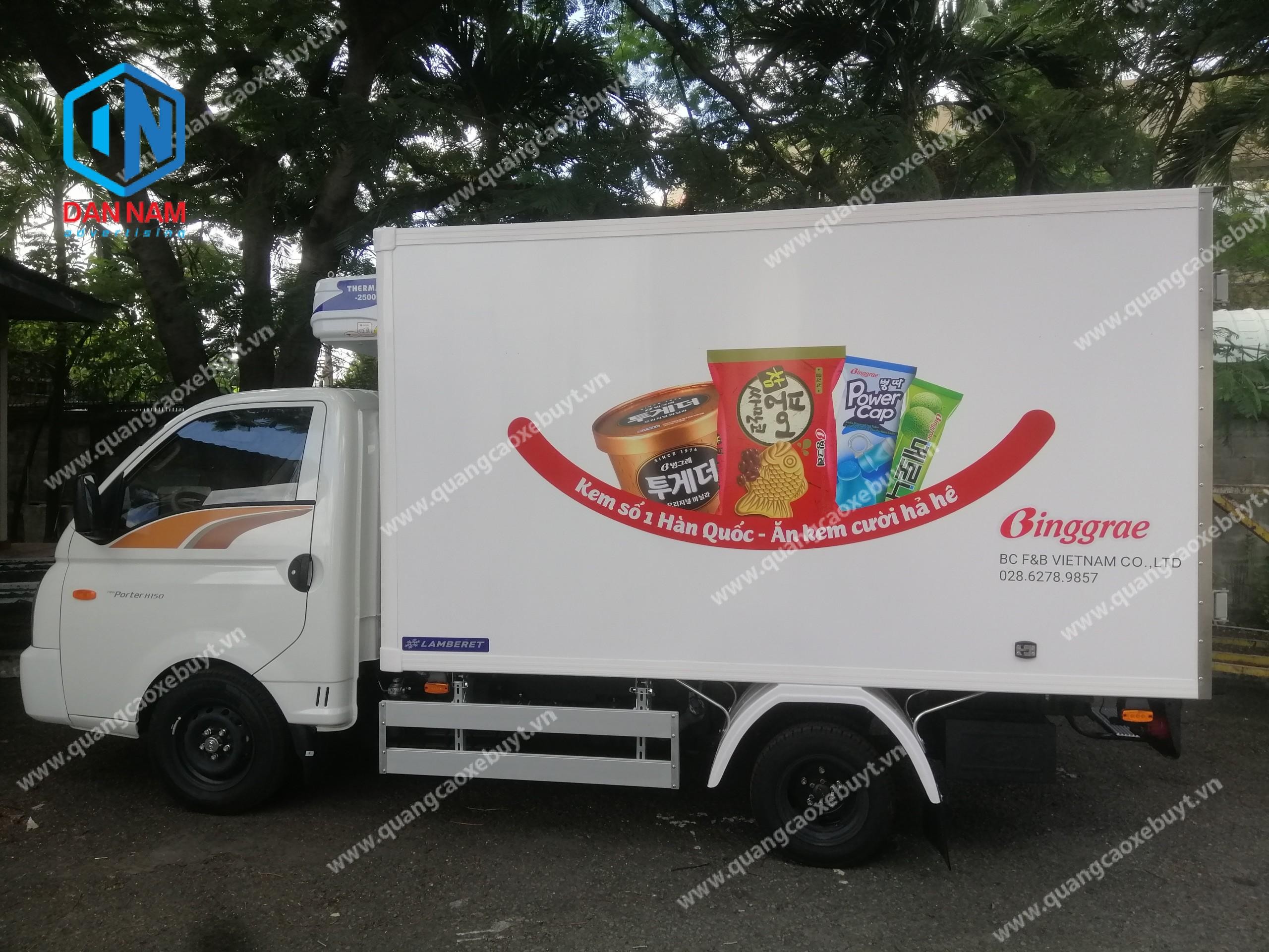Hình ảnh xe tải đông lạnh đã dán decal quảng cáo thùng xe gợn sóng, hoạt động trên đường phố