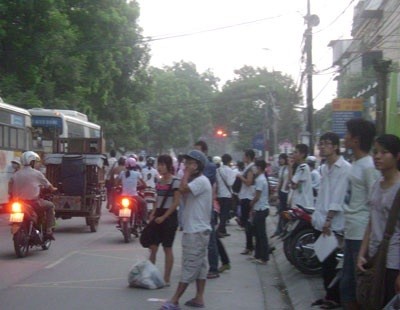 Sinh viên mệt mỏi chờ xe bus quá tải trong giờ cao điểm tại điểm dừng xe buýt trên đường Nguyễn Trãi, Hà Nội.