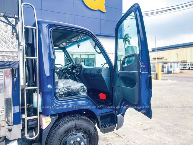 Camião Hyundai Mighty 110SL com contentor de lona em frente à fábrica