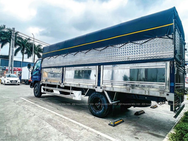 Camião Hyundai Mighty 110SL com contentor de lona branco estacionado na estrada