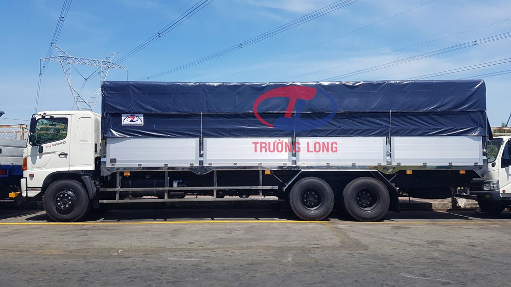Camião Hino de 3 eixos com toldo a transportar materiais de construção