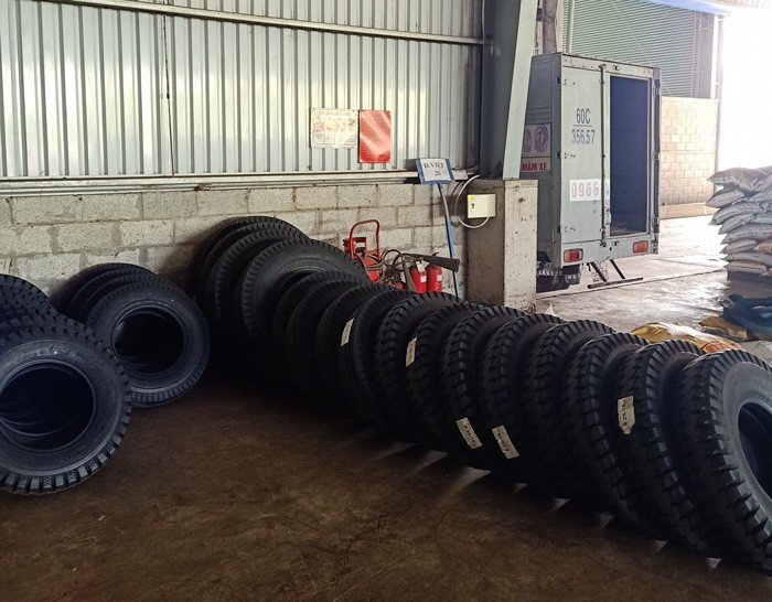 Le logo du concessionnaire Xe Tải Mỹ Đình affiché avec des pneus Maxxis en arrière-plan