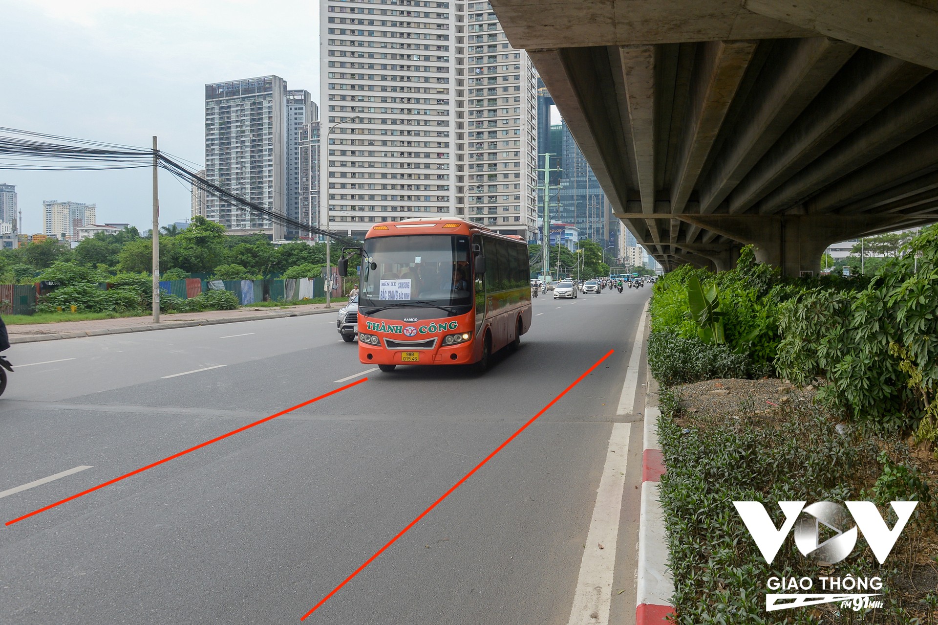 Ảnh chụp xe khách được lực lượng chức năng hướng dẫn di chuyển vào làn đường riêng, sát dải phân cách, trên đường Phạm Hùng, đoạn gần bến xe Mỹ Đình, để tránh tình trạng dừng đỗ sai quy định.