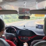 Giáo viên hướng dẫn học viên nữ tập lái xe trên sân sát hạch
