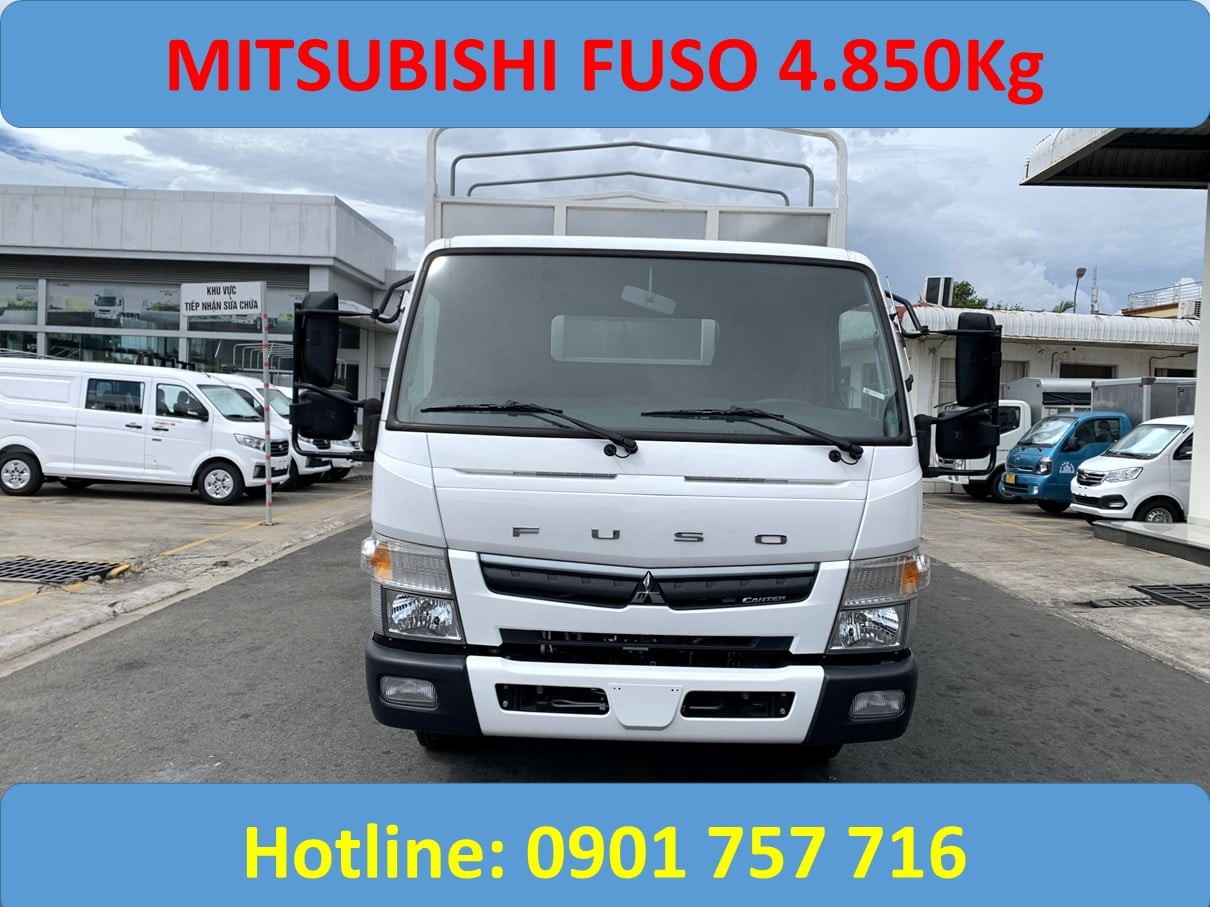 alt text: Xe tải Fuso 5 tấn thùng mui bạt, màu xanh, đang di chuyển trên đường.