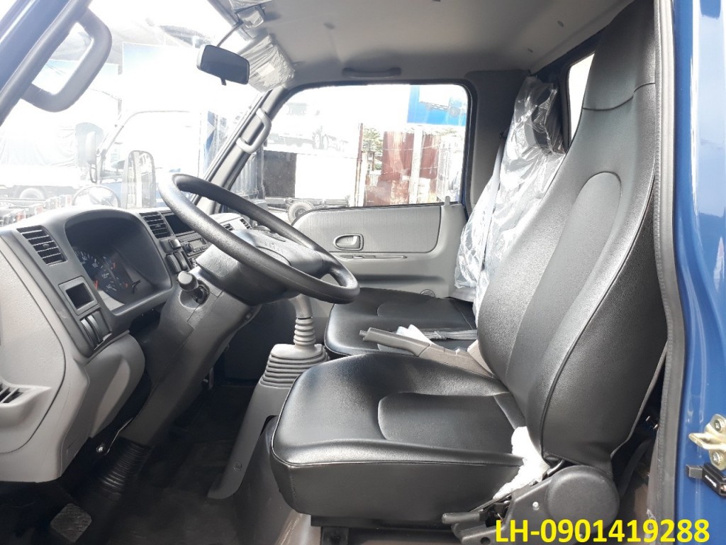 Intérieur de la cabine d'un camion Đô Thành IZ49, montrant le tableau de bord, les sièges et le volant