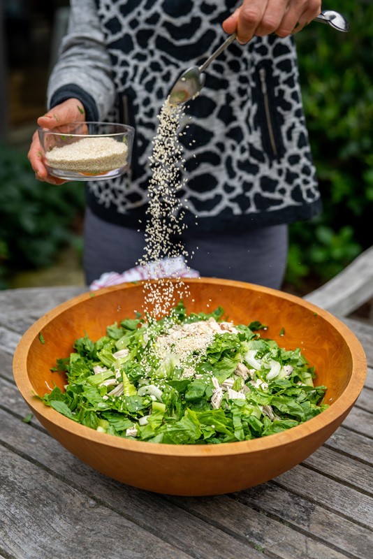 Erin rắc hạt mè lên salad