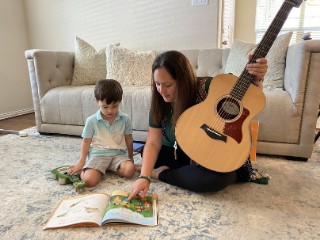 Hình ảnh một em bé đang vui vẻ chơi đàn ukulele