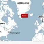 Bản đồ vị trí của Greenland so với Canada, Hoa Kỳ và Đan Mạch, với Nuuk được đánh dấu là thủ đô của Greenland. Một quả địa cầu đánh dấu vị trí của Greenland ở vùng Bắc Cực