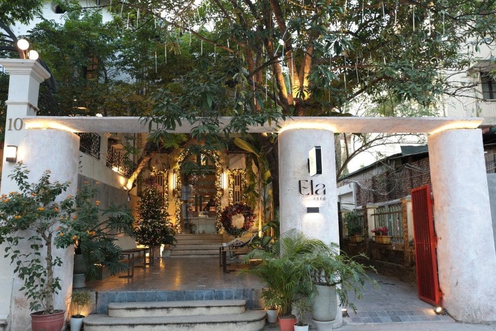 Toàn cảnh không gian bên ngoài quán Ela Cafe với cây xanh và kiến trúc cổ điển