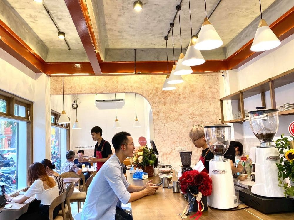 Không gian tầng 1 quán cafe Hermanas Khúc Hạo với cây xanh và ánh sáng tự nhiên
