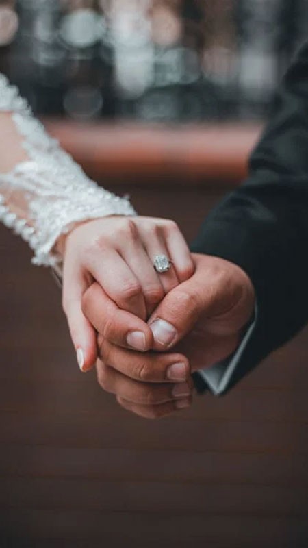 Đôi bàn tay đeo nhẫn đôi, thể hiện sự gắn kết và cam kết trong tình yêu.