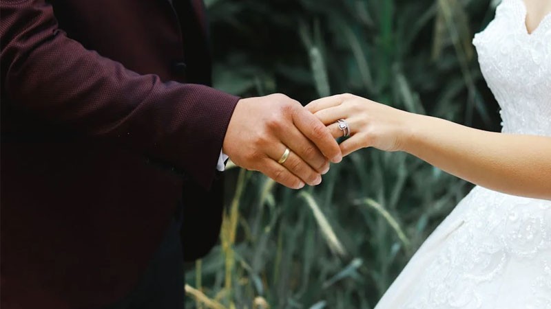 Cặp đôi nắm tay nhau khi xem phim ở nhà, thể hiện sự thoải mái và gần gũi.