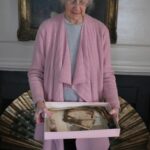 Connie Congdon holds a box filled with five artifacts a mason found in the chimney of her Nantucket home: 19th-century letters; a man