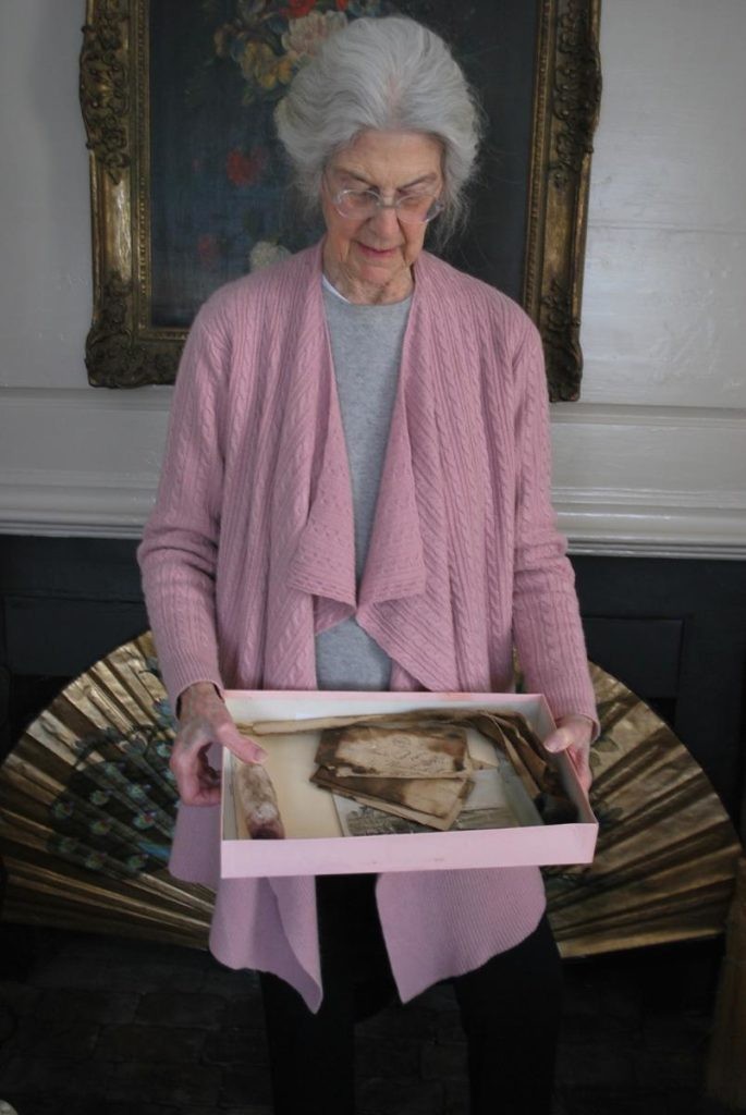 Connie Congdon holds a box filled with five artifacts a mason found in the chimney of her Nantucket home: 19th-century letters; a man