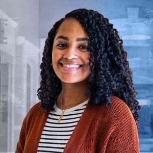 Alexis Green với áo len cam và áo поло sọc