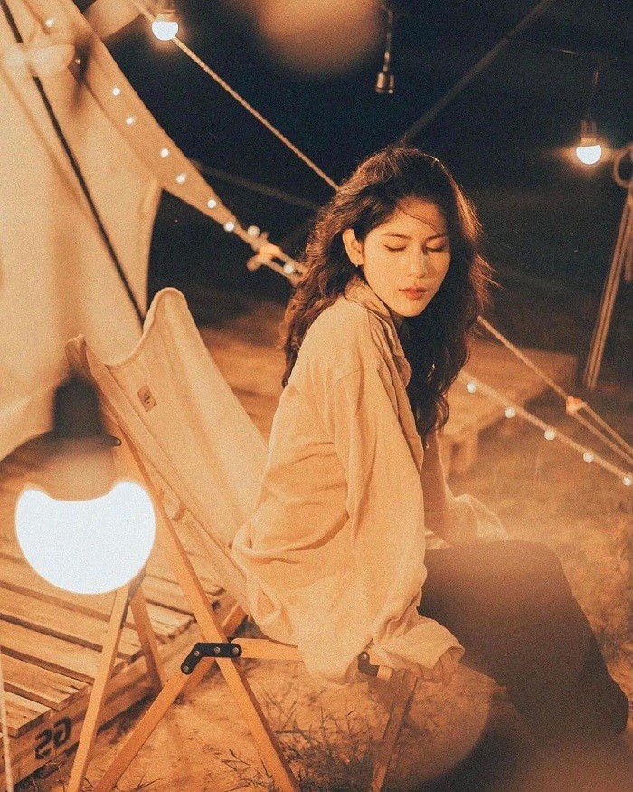 Một nhóm bạn trẻ cắm trại bên hồ Dầu Tiếng vào ban đêm, cùng nhau ca hát và thưởng thức không khí trong lành