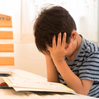 Cậu bé đang vật lộn với bài tập về nhà