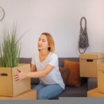 Một người phụ nữ trẻ đang kéo vali đi trên phố đông đúc, thể hiện sự tự do và khám phá cuộc sống mới ở thành phố.