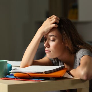 Cô gái mệt mỏi đang cố gắng hoàn thành bài tập về nhà