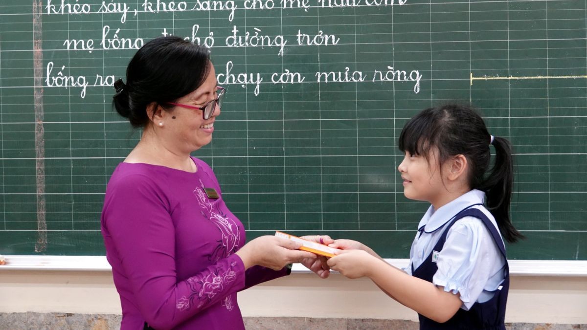 Một nhóm học sinh đang tặng hoa cho giáo viên của mình trong một buổi lễ tri ân, thể hiện lòng biết ơn và sự kính trọng dành cho những người đã cống hiến cho sự nghiệp giáo dục