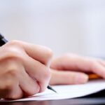 Cậu bé rụt rè bên mẹ trong ngày khai trường, thể hiện sự ngây thơ và bỡ ngỡ