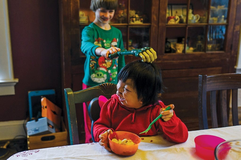 Vincent teases his sister Mei Ting, 6, with a toy claw. Photo by Allison Mah