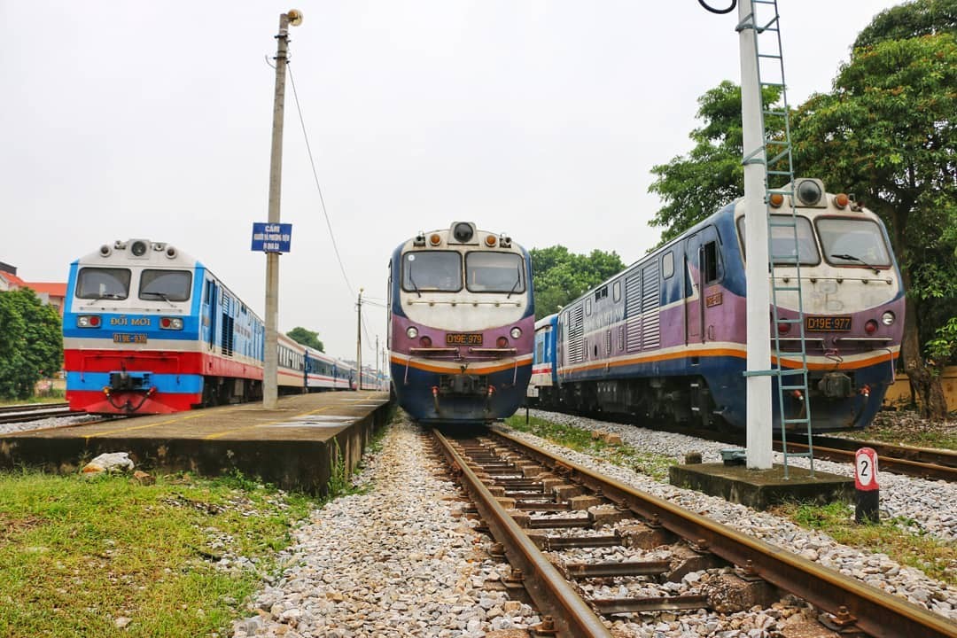 Hình ảnh đường sắt Hà Nội - Huế với đoàn tàu đang di chuyển qua vùng quê yên bình, thể hiện sự kết nối giữa hai thành phố
