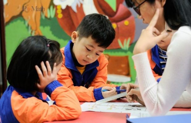 Hình ảnh minh họa: Bé đang chăm chỉ làm bài tập toán, với sự hướng dẫn và động viên của phụ huynh.