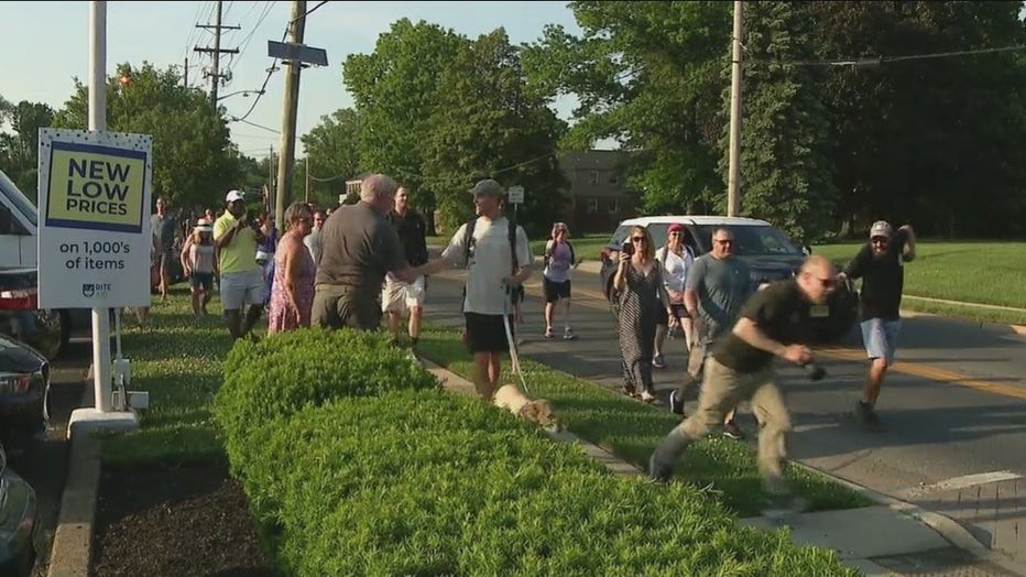 Tom Turcich greets well-wishers as he and his dog walk the last few miles towards his home