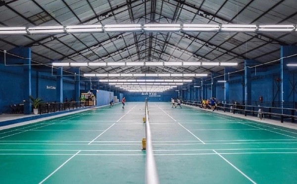Sân cầu lông với mặt thảm xanh và hệ thống ánh sáng đạt chuẩn